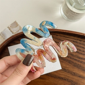 French wavy acetate hair claw clip with marble texture in blue and orange pink