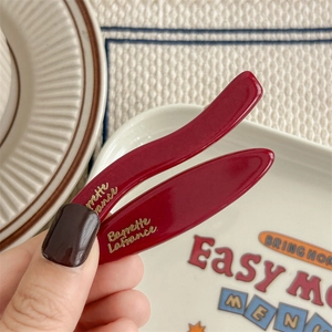Elegante coppia di fermagli per capelli rosso vino con scritte dorate su sfondo vintage francese