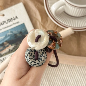 Elastic acetate hair ties with tortoiseshell button charms in three elegant patterns
