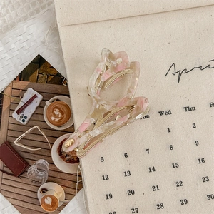 Detalle de pinza para el pelo de tulipa en acetato con textura de mármol rosa y blanco