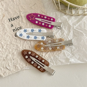 Set of four floral rhinestone hair clips in purple, white, amber, and coffee colors