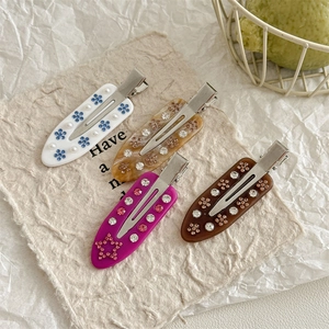 Set of four floral duckbill hair clips with rhinestones and elegant resin finishes