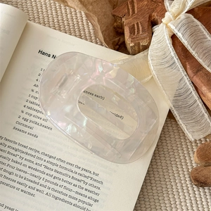 Detailansicht einer Haarspange aus Perlmutt-Acetat auf einem Vintage-Buch