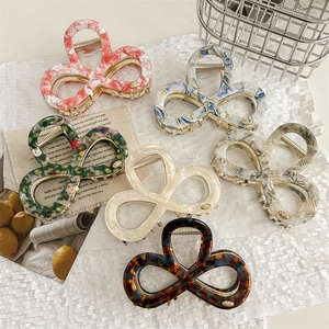 Elegant bow-shaped acetate hair claws in various marble and tortoiseshell patterns