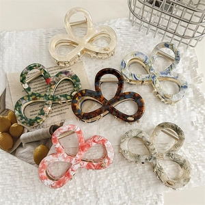 Elegant bow-shaped metal hair claws in various marble patterns for a minimalist look