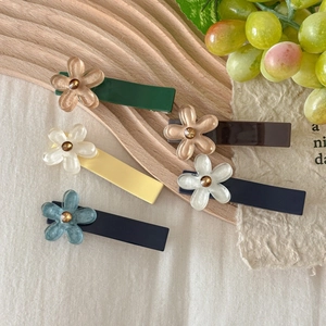 Five-piece set of elegant flower hair clips in various colors on a wooden tray