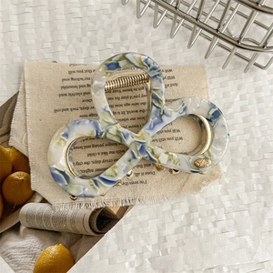 Detail of elegant tricolor marble acetate hair claw clip with strong metal spring