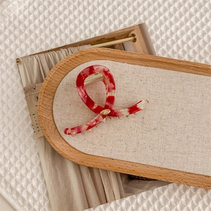 Détail de la pince à cheveux motif écaille de tortue rouge et blanc avec ressort doré