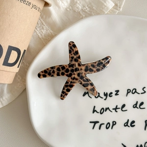 Detail view of starfish-shaped acetate hair clip with tortoiseshell leopard pattern