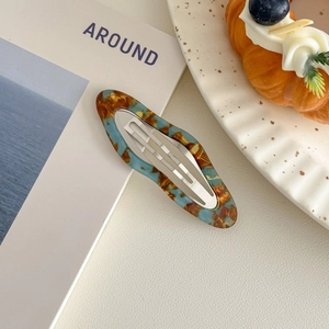 Detail of elegant acetate hair clip with vintage blue amber texture on a lifestyle setting