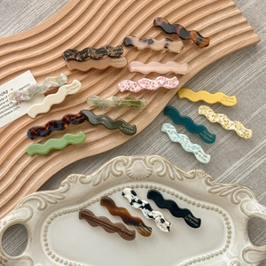 Lake blue wavy acetate hair clips in various marble patterns for elegant hair styling
