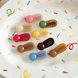 Minimalist round ball hair clips in nine assorted colors displayed on a decorative plate