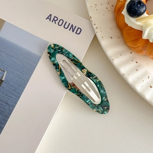 Detail view of oval acetate hair clip with marble texture on aesthetic lifestyle background