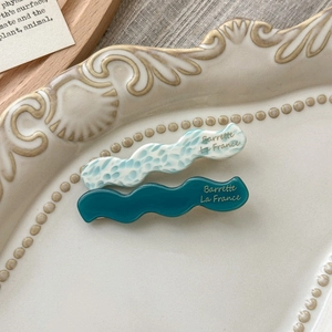 Detail of blue marble and teal acetate wave hair clips on vintage ceramic plate