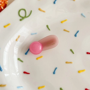 Detail showing pink matte hair clip with golden France Handmade text on ceramic plate