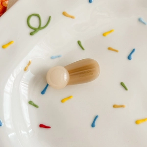 Detailed macro of a caramel resin hair clip with engraved France Handmade lettering
