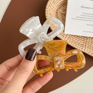Elegant acetate bow hair clips with rhinestones in white pearl and amber marble patterns