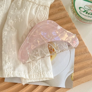 Détail de la pince à cheveux rose avec texture marbrée et gravure française élégante