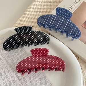 Polka dot hair claw clip set in navy, black and red on a ceramic display tray