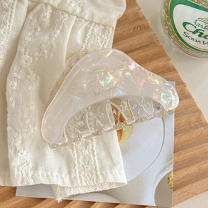 Détail d'une pince à cheveux en acétate crème irisé avec inscription Barrette La France