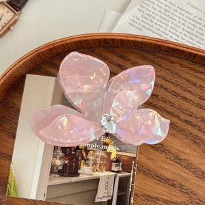 Vue détaillée d'une pince à cheveux florale rose nacré avec des détails en diamant goutte