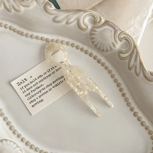 Detailed macro of handmade cream marble hair fork with engraved France handmade logo