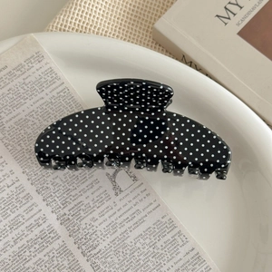 Detailed view of the black and white polka dot hair claw on a decorative tray