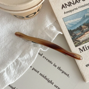 Détail d'une barrette en acétate marron ambre avec gravure dorée France Handmade