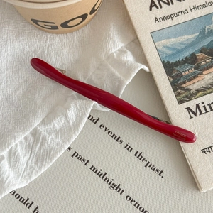 Détail d'une barrette en acétate rouge avec inscription France Handmade dorée sur tissu