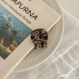 Close-up of tortoise shell pattern acetate hair claw with France handmade gold text