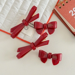 Deep red acetate bow hair clip set with France Handmade text on white fabric background