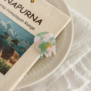 Detailed close-up of marble pattern acetate hair claw clip with France handmade gold lettering