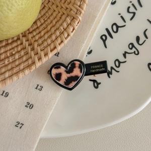 Detail of a leopard print heart hair clip showing the France Handmade craft text