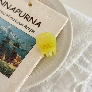 Close-up of yellow resin mini hair claw clip featuring France Handmade engraving