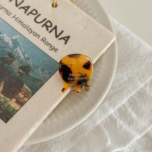 Detailed shot of amber tortoiseshell claw clip with France Handmade text on ceramic plate