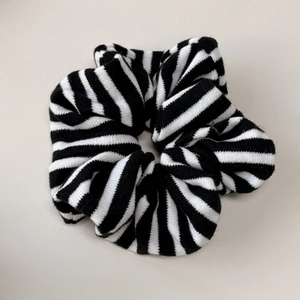Gros plan sur la texture tricotée et le motif rayé noir et blanc sur le chouchou