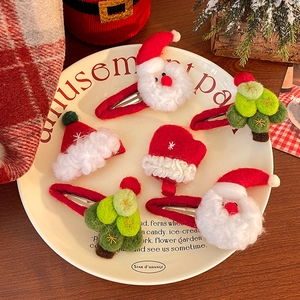 Barrettes de Noël en peluche avec Père Noël et sapin disposées sur une assiette