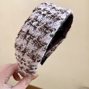 Close-up of a wide pink and brown tweed headband with metallic gold fiber texture