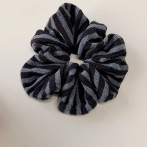 Détail d'un chouchou rayé en maille douce noir et gris pour coiffure quotidienne