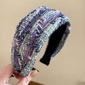 Close-up of thick multi-color tweed headband featuring woven texture and padded design