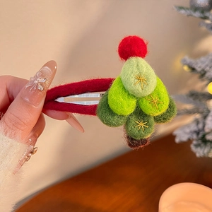 Détail d'une barrette sapin de Noël en feutrine faite main avec broderies dorées