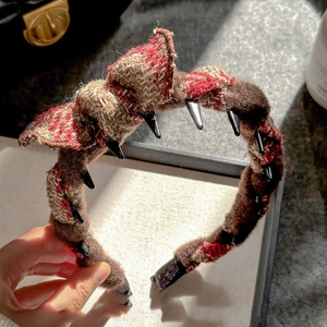Detail of tweed headband with brown and red woven fabric and inner black grip teeth