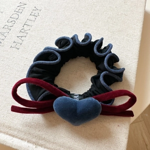 Velvet bow scrunchie with denim lace edge and heart pendant on a soft background