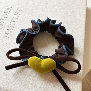 Close-up of velvet heart and denim lace trim on a retro brown scrunchie hair tie