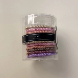 Détail d'élastiques à cheveux tressés haute élasticité avec perles dorées et boîte
