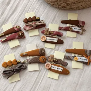 Detailed view of handmade bear plaid hair clips with corduroy and button accents