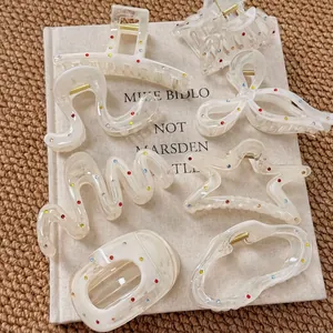 Elegant cream resin hair claws with colorful rhinestones in star and bow shapes
