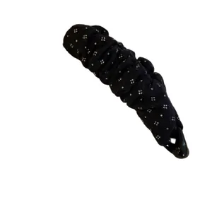 Elegant black banana hair clip with white floral pattern and glossy plastic finish