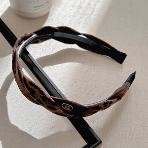 Detailed macro view of leopard print headband with non-slip teeth and gold metal plate
