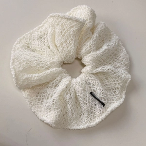 Gros plan du chouchou blanc en dentelle ajourée avec étiquette fait main et crochet rétro